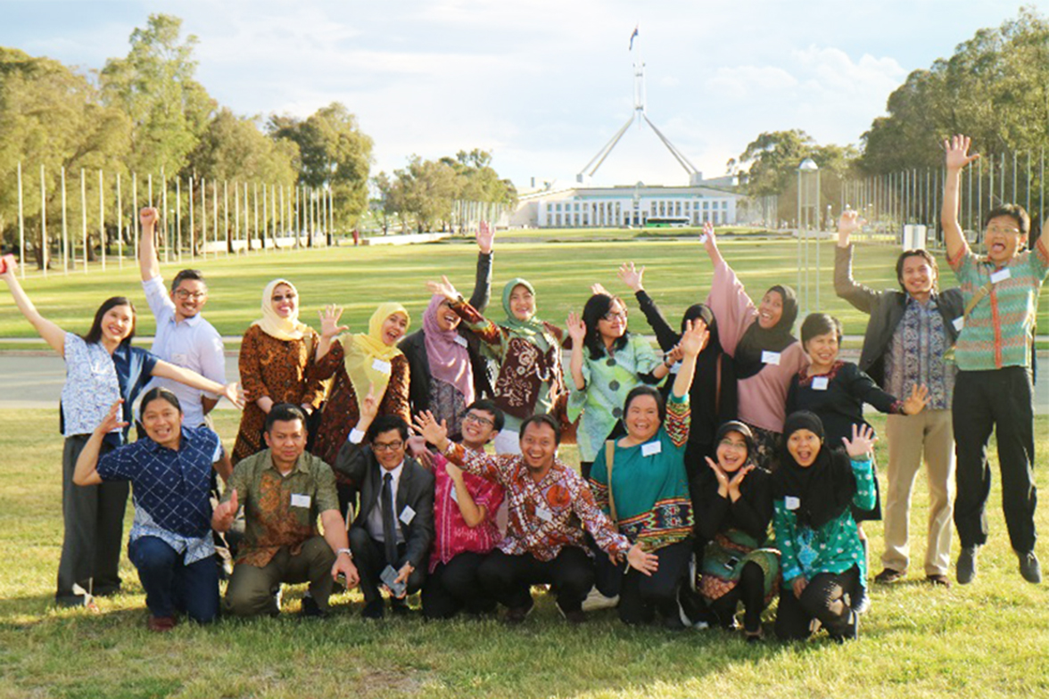 A group of people smiling and waving hands